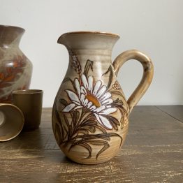 Joli décor végétal intemporel pour ce pichet des années 60 par Jacques Fonck et Jean Mateo à signaler: une petite ébréchure sous le pichet, invisible Poids: 0.8kg Dimensions: 20cm de haut et 8cm de diamètre en sa base 