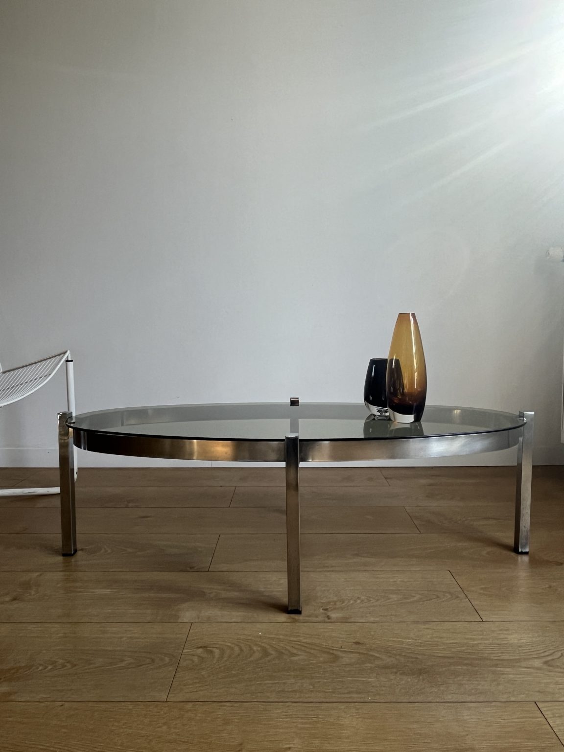 Table des années 70 avec plateau ovale verre fumé et pied tulipe chromé